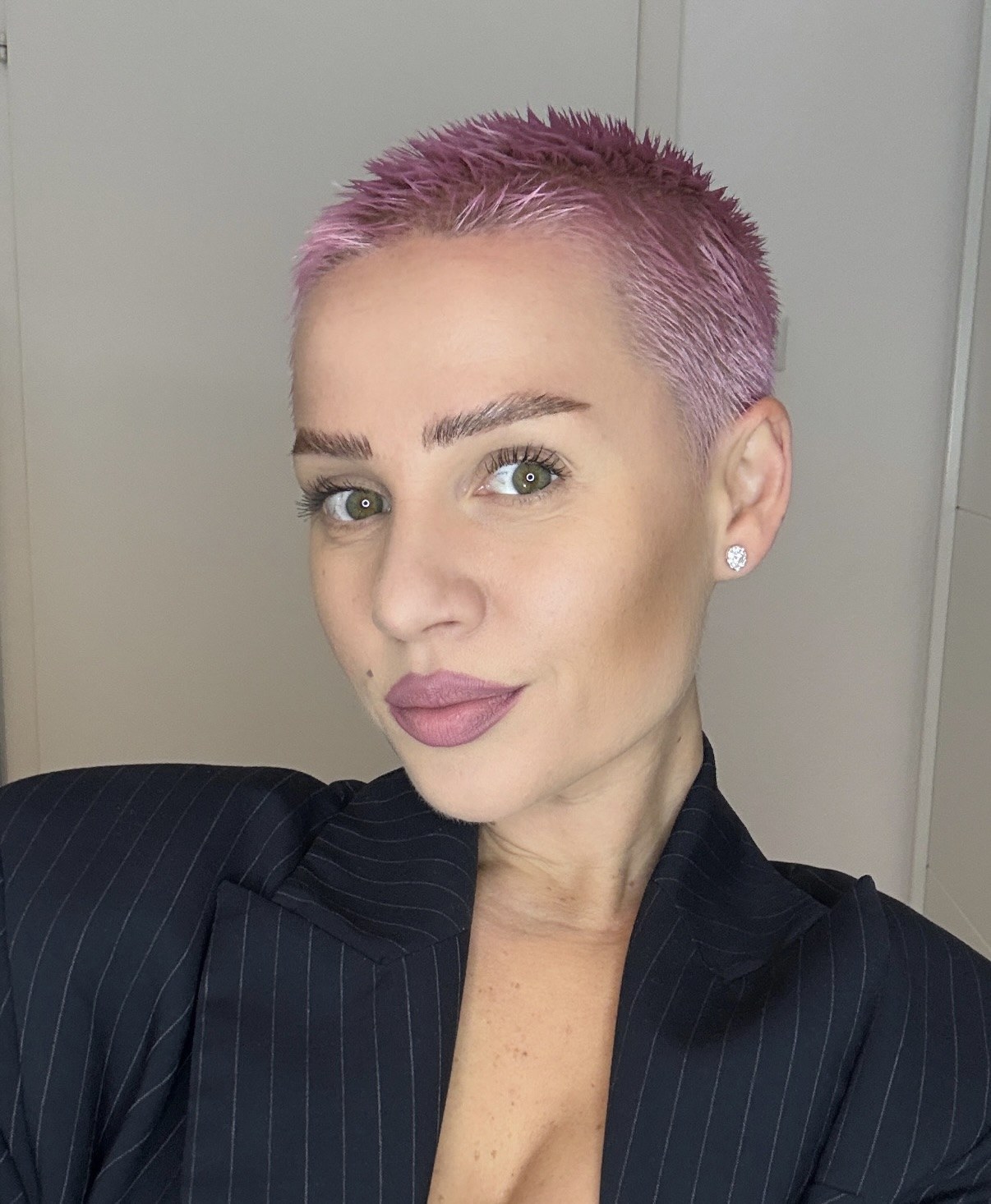 Kiva with pink hair in a pinstripe blazer
